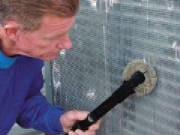 Technician cleaning a condenser coil